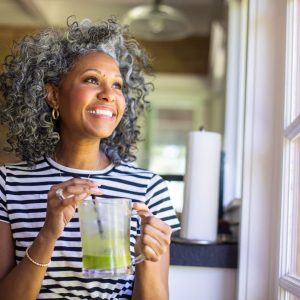 Middle aged woman looking out of window smiling