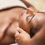 woman laying on the bed receiving a facial treatment from an esthetician